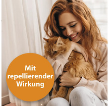 Frau umarmt Katze mit repellierender Wirkung