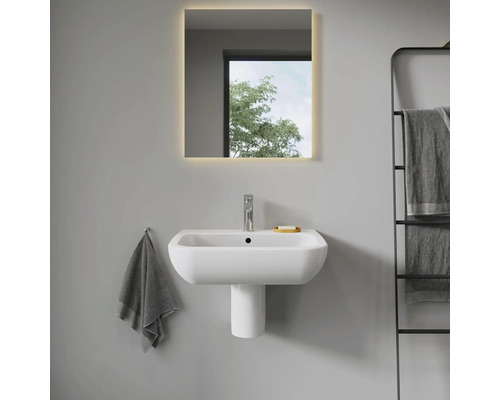 Modernes Badezimmer mit Waschbecken, Waschtischsäule und beleuchtetem Spiegel