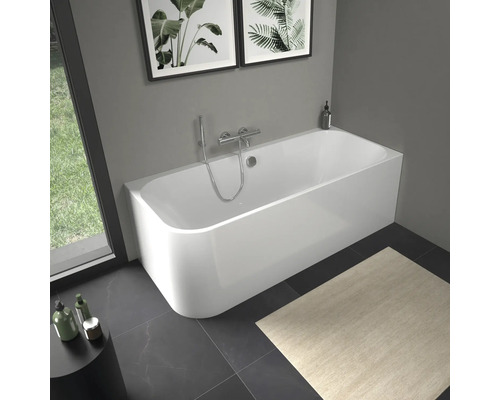 Weiße Badewanne mit Armatur in Badezimmer