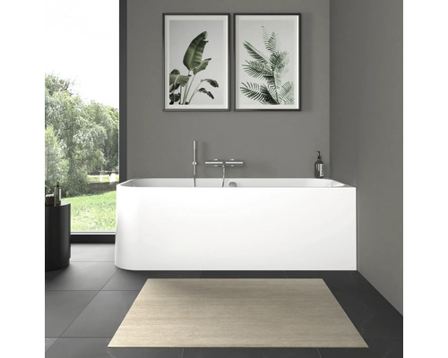 Modernes Badezimmer mit freistehender Badewanne, Armatur und Pflanzenbildern.