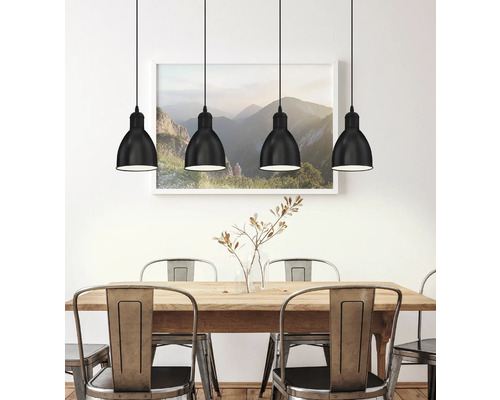 Esszimmer mit Holztisch, Metallstühlen und vier schwarzen Hängelampen