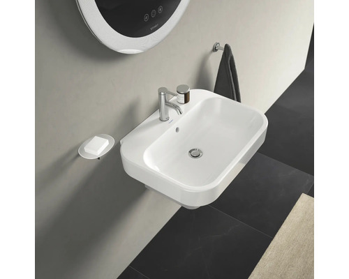 Helles Badezimmer mit Waschbecken, Seifenspender, Spiegel und Handtuchhalter.