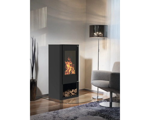 Kaminofen mit Holzfach, Glasfenster und brennendem Feuer in einem Wohnzimmer