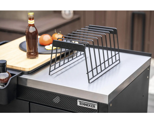 Ablagerost aus Metall auf einer Grillstation mit Flasche, Tomaten und Schneidebrett