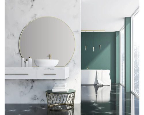 Helles Badezimmer mit Marmorwand, Waschbeckenunterschrank, rundem Spiegel und Badewanne