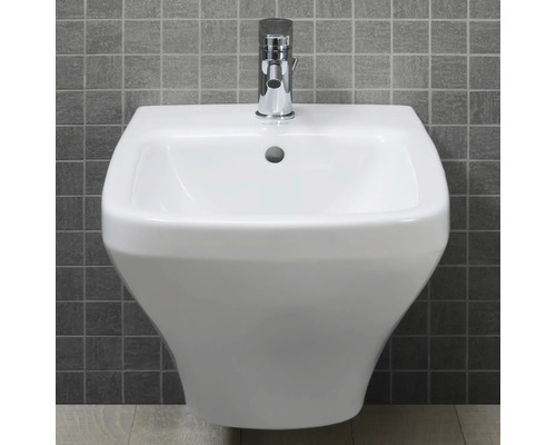 Weißes Keramik Waschbecken mit Armatur an grauer Wand