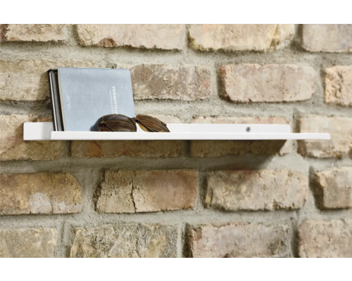 Weißes Wandregal mit Buch und Sonnenbrille an einer Ziegelwand