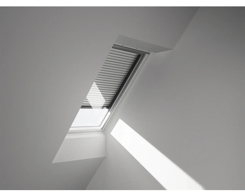 Dachfenster mit geschlossenem Rollladen in einem hellen Raum