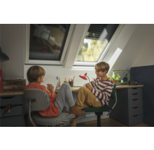 Zwei Kinder sitzen an einem Schreibtisch mit Dachfenstern für natürliches Licht.