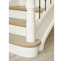 Detailaufnahme einer Treppe mit Holzstufen, weißem Geländer und einem Treppenpfosten