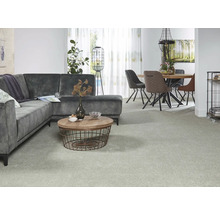 Wohnzimmer mit grauem Ecksofa, rundem Couchtisch, Esstisch und Stühlen auf Teppich