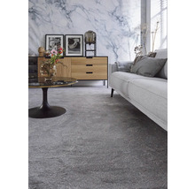Wohnzimmer mit grauem Teppichboden, Sofa und Sideboard vor einer Marmorwand