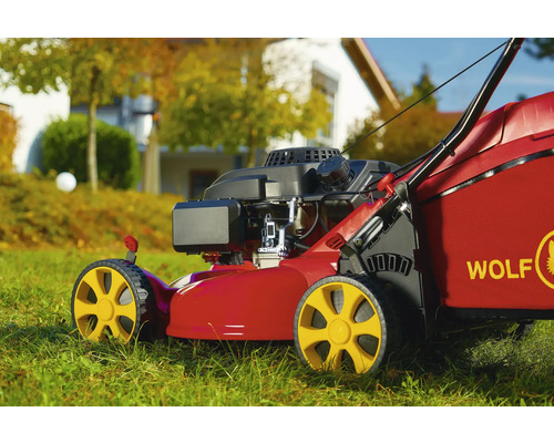 Roter Rasenmäher der Marke Wolf auf Rasen
