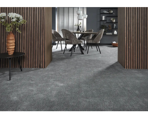 Innenraum mit grauem Teppichboden, Esstisch mit Stühlen, hölzerner Wandverkleidung und dekorativen Elementen.