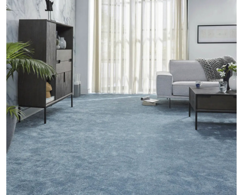 Wohnzimmer mit blauem Teppichboden, Sofa, Tisch und Schrank