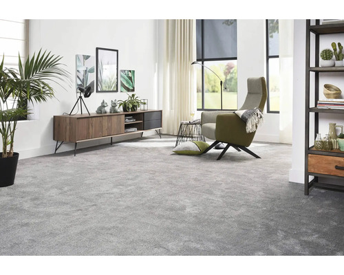 Wohnzimmer mit Teppichboden, Sideboard, Sessel und Zimmerpflanzen für eine wohnliche Atmosphäre.