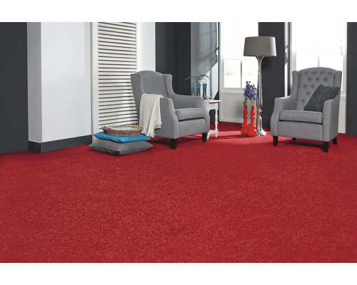 Wohnzimmer mit rotem Teppich, zwei grauen Sesseln und dekorativen Elementen