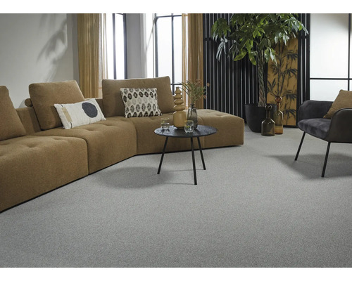 Wohnzimmer mit grauem Teppichboden, braunem Ecksofa und Dekorationen