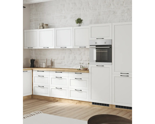 Helle Küche mit weißen Schränken, Holzplatte und eingebautem Ofen.