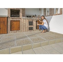 Außenküche mit gemauertem Grill, Holzschränken und Betonplattenboden