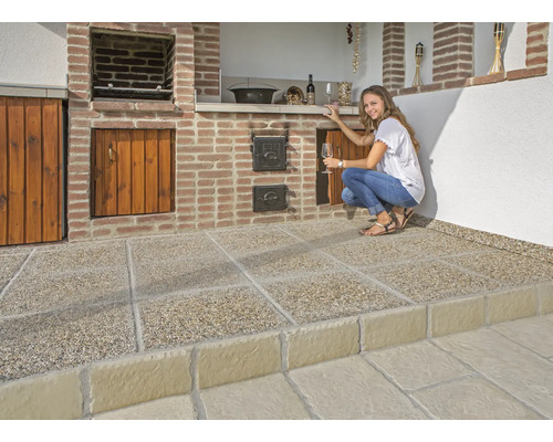 Außenküche mit Grillstelle, Holzschränken, gemauerter Arbeitsfläche und Terrassenplatten