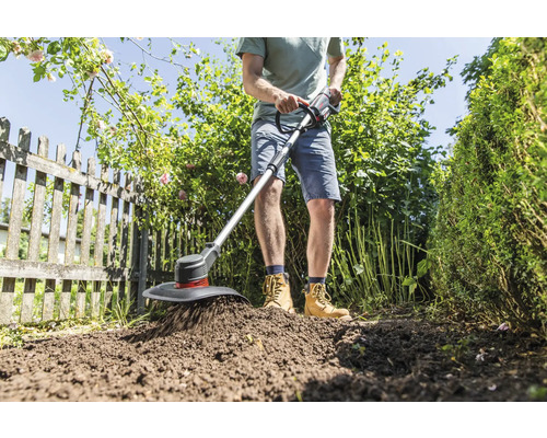 Ein Mann arbeitet mit einem Akku-Bodenkrümler im Garten, um den Boden zu lockern.