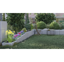 Gestalteter Garten mit Betonpflanzkästen, Blumen und Rasenfläche