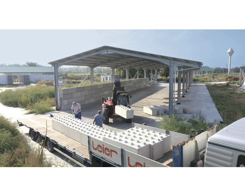 Anlieferung von Betonbausteinen auf einer Baustelle mit Gabelstapler