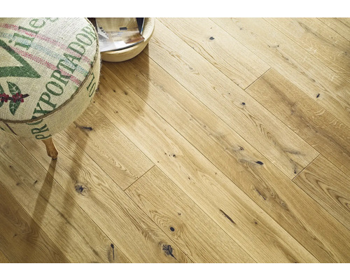 Verlegung von hellem Holzlaminat mit Hocker und Dekoschale