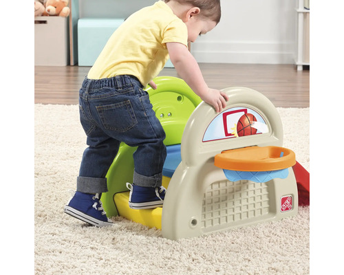 Kleinkind klettert auf Spielplatz mit Basketballkorb