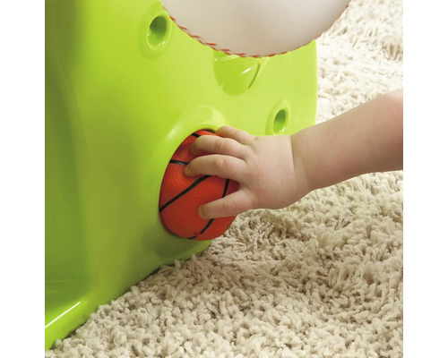 Ein Kind steckt einen Ball in ein Spielzeug.