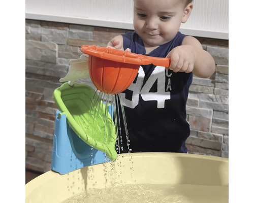 Kind spielt mit einem Wasserspielzeug über einem Wasserbecken