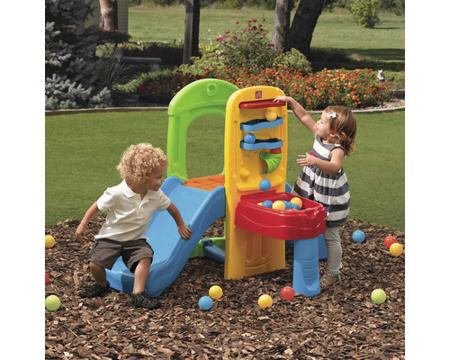 Kinder spielen mit einem Step2 Klettergerüst mit Rutsche und Ballrampe im Garten.