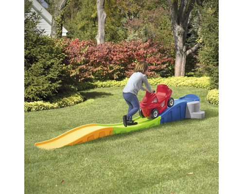 Mädchen schiebt rotes Rutschauto auf einer Achterbahn für den Garten