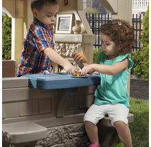 Zwei Kinder spielen mit einem Outdoor-Spielhaus mit Spielküche.