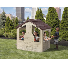 Spielhaus für Kinder mit braunem Dach und spielenden Kindern im Garten.