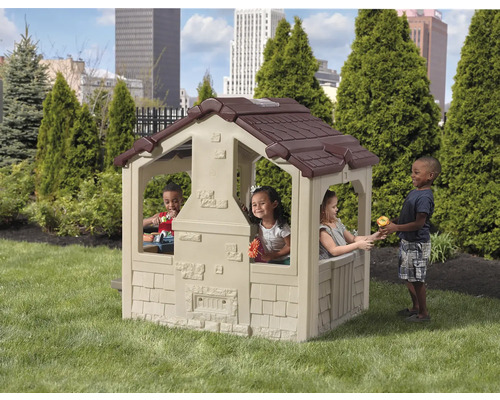 Spielhaus für Kinder mit braunem Dach und spielenden Kindern im Garten.