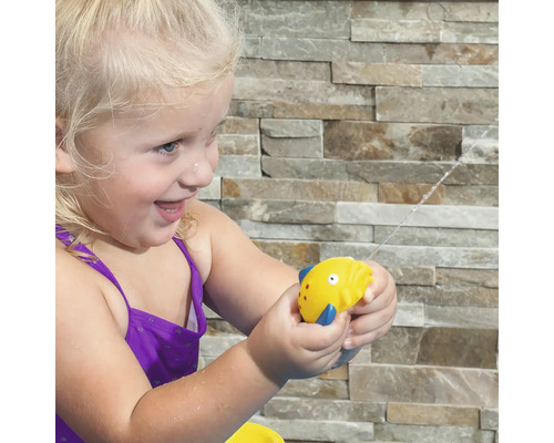 Mädchen mit Wasserspritzpistole in Fischform im Garten