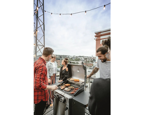 Gruppe von Menschen grillt auf einem Gasgrill im Freien