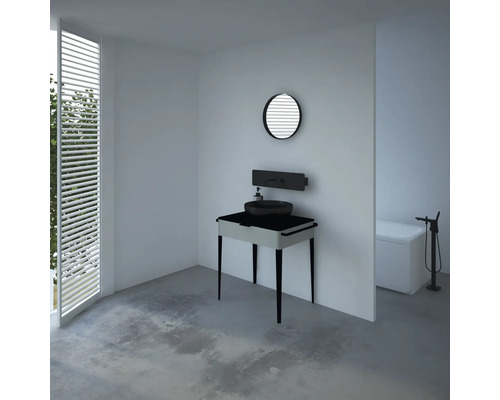 Badezimmer mit Waschbecken auf Waschtisch, rundem Spiegel und Badewanne