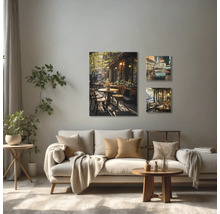 Wohnzimmer mit Sofa und drei Wandbildern mit Café-Motiven