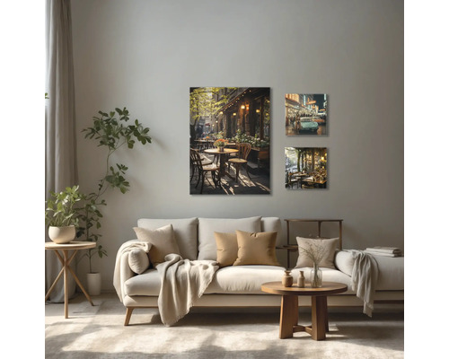 Wohnzimmer mit Sofa und drei Wandbildern mit Café-Motiven