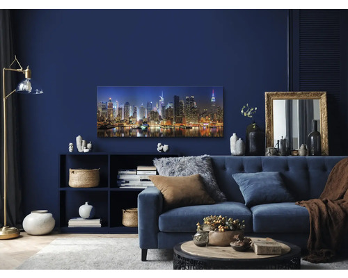 Wohnzimmer mit blauem Sofa, Regal und New York Skyline Wandbild