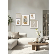 Wohnzimmer mit Sofa, Couchtisch und Wand mit fünf gerahmten Kunstdrucken