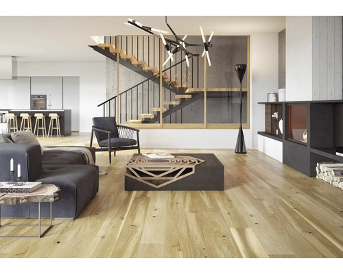 Heller Wohnraum mit Treppe, Sitzmöbeln, Couchtisch und Kamin.