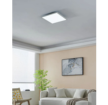 Wohnzimmer mit quadratischer LED Deckenleuchte, Sofa, Sessel, Zimmerpflanze und Bild