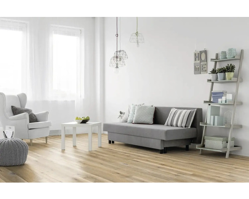 Helles Wohnzimmer mit Sofa, Sessel, Tisch und Regal