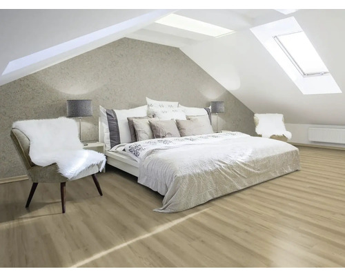 Helles Schlafzimmer im Dachgeschoss mit Dachfenstern, Bett und Stuhl