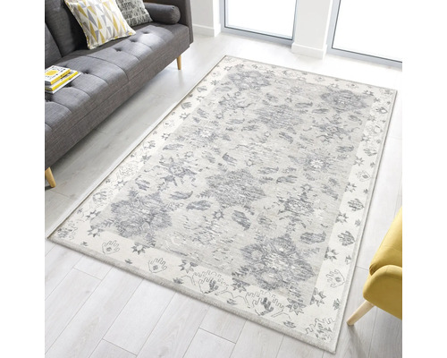 Teppich mit grauem Blumenmuster in einem Wohnzimmer mit Sofa