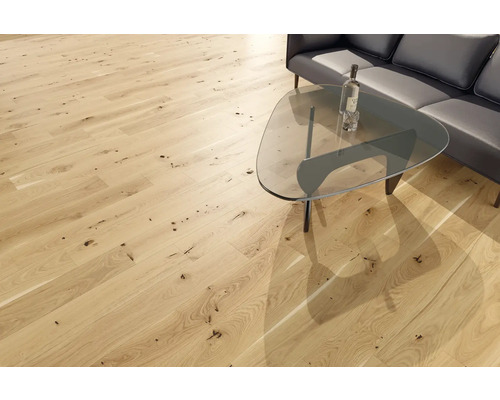 Heller Holzboden mit Astlöchern in einem Wohnzimmer mit Couch und Tisch.